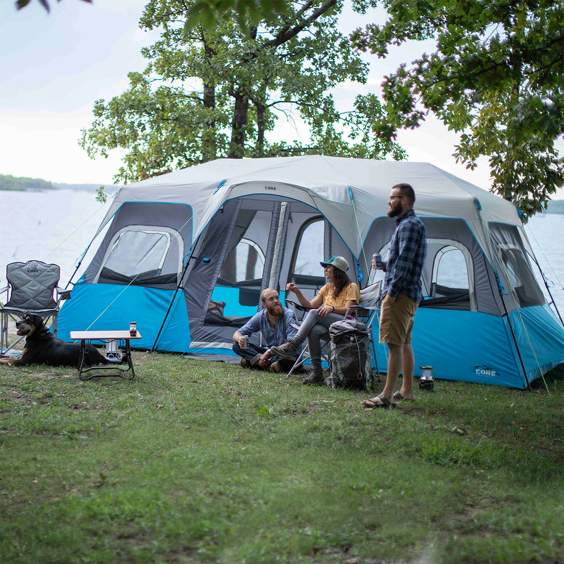 A large, brown CORE 12-person instant cabin tent measuring 18 feet by 10 feet. The tent features built-in LED lights for added convenience and safety, and it has a spacious interior, multiple windows, and a sturdy frame for easy setup.