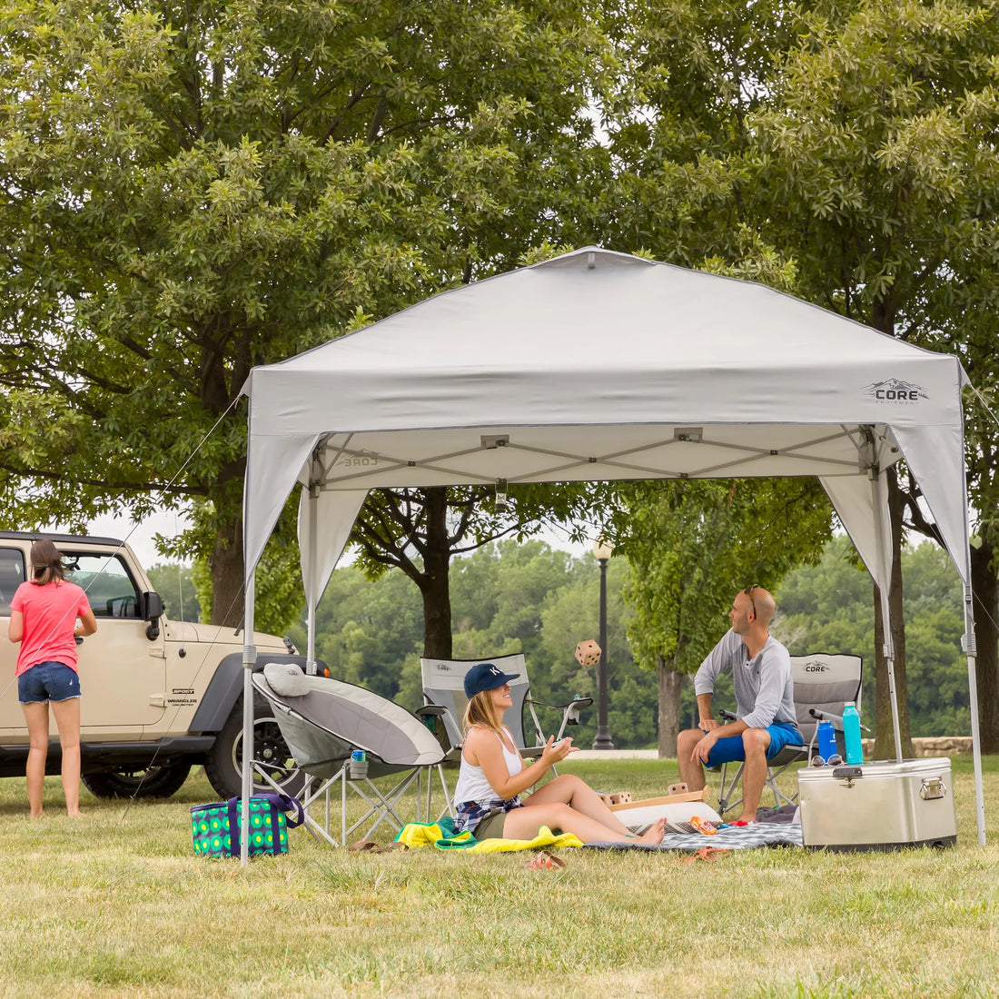 A large, orange and gray CORE 10' x 10' instant canopy, also known as a gazebo. The canopy has a pop-up design for quick and easy setup, and it provides shade and shelter for outdoor activities.